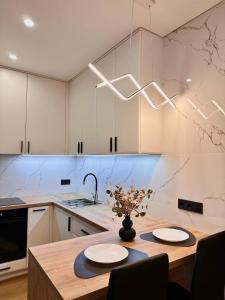een keuken met een tafel met daarop een vaas met bloemen bij New Business-Class Apartament з генератором Varshavsky Retroville in Kiev