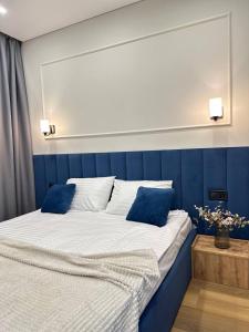 een slaapkamer met een groot bed met blauwe muren bij New Business-Class Apartament з генератором Varshavsky Retroville in Kiev