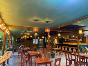 ein Restaurant mit Holztischen und Stühlen und einer Bar in der Unterkunft Eco Terra Lodge in Santa María + 39 Fotos