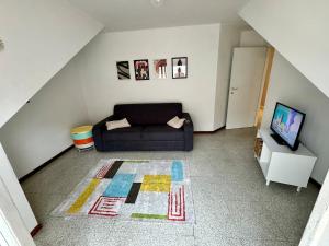 een woonkamer met een bank en een televisie bij ARIEL'S house in San Benedetto del Tronto