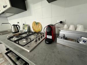 a kitchen counter with a stove and a red blender at ARIEL'S house in San Benedetto del Tronto +4 photos