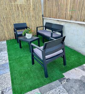tre sedie nere e un tavolo sull'erba verde di ARIEL'S house a San Benedetto del Tronto