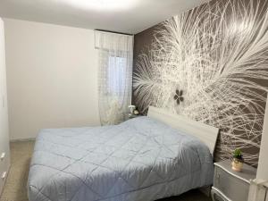 een slaapkamer met een bed en een muurschildering bij ARIEL'S house in San Benedetto del Tronto