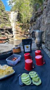 un tavolo con cibo e bevande su una tovaglia blu di Chalé Família Canto da Graúna a Ibicoara