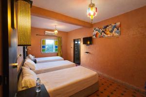 ein Hotelzimmer mit 4 Betten in Folge in der Unterkunft Gite Souss in Oulad Teïma