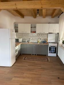 una cucina con elettrodomestici bianchi e frigorifero bianco di Casa Diana a Huedin