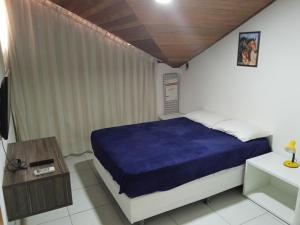 una camera da letto con un letto con una coperta blu di Monte Castelo Flat Temporada a Gravatá Altre 48 foto