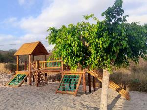 un parco giochi in legno con un albero e un gazebo di Monte Castelo Flat Temporada a Gravatá