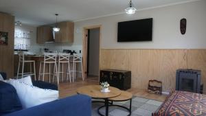 a living room with a couch and a fire place at Lodge Perry Barnes in Puerto Varas