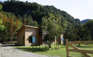 a small wooden cabin with a mountain in the background at Lodge Perry Barnes in Puerto Varas