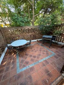 een patio met een tafel, 2 stoelen en een bank bij Duplex 5 personas pinamar centro in Pinamar +7 foto's
