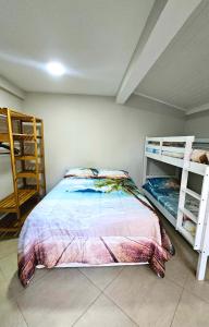 een slaapkamer met een bed en 2 stapelbedden bij Flat Maresias Beira Mar in Maresias +19 foto's