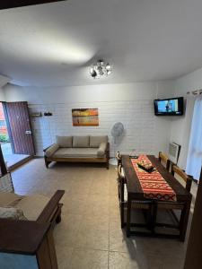 een woonkamer met een bank en een tafel bij Duplex 5 personas pinamar centro in Pinamar