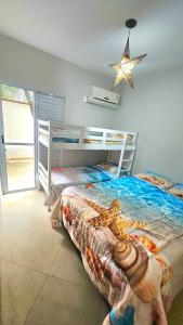 een slaapkamer met een bed met een ster aan de muur bij Flat Maresias Beira Mar in Maresias