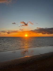 een zonsondergang op het strand met de oceaan bij Maraga Bento in Maragogi +2 foto's