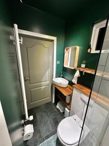 La salle de bains est pourvue de toilettes et d'un mur vert. dans l'établissement Travelers Studio, à Njarðvík 8 autres photos