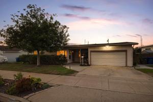 a house with a garage and a tree in front of it at Pool Oasis Central Villa in El Cajon