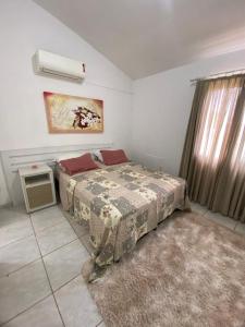 een slaapkamer met een bed in een kamer met een raam bij Sobrado Colinas in Balneário Camboriú +12 foto's
