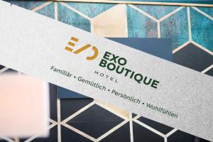 a sign for an exo boutique hotel on a tiled wall at eXo Boutique Hotel Mannheim - by SuperFly Hotels in Mannheim