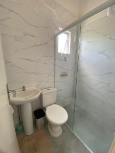 een badkamer met een toilet, een wastafel en een douche bij Sobrado Colinas in Balneário Camboriú
