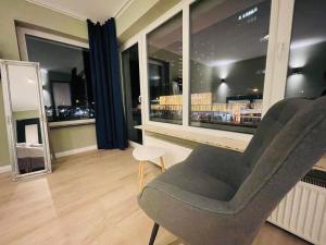een woonkamer met een stoel en een groot raam bij Milano Apartment in Hamburg +51 foto's