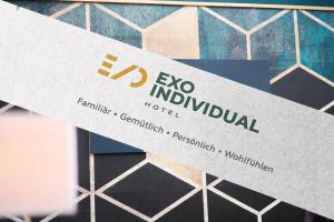 a sign for an exo individual hotel on a tile wall at eXo Individual Hotel Waghäusel - by SuperFly Hotels in Waghäusel
