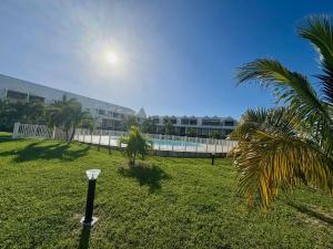 a yard with a palm tree and a building at Pearl View Condo in Baie Nettle