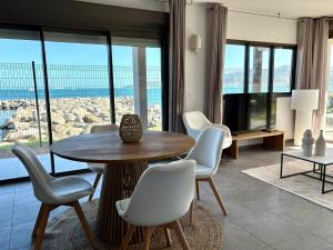 a living room with a table and chairs with a view at Pearl View Condo in Baie Nettle
