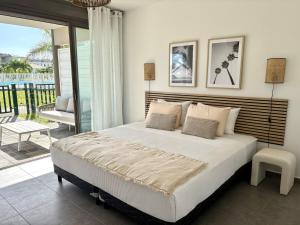 a bedroom with a large bed and a balcony at Pearl View Condo in Baie Nettle +27 photos