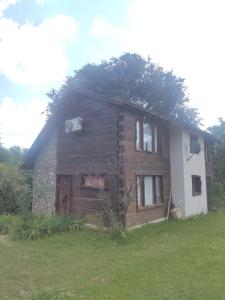 una casa con un albero sopra di Cabañas Yacoana a Valle Hermoso
