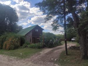 un fienile con un tetto verde su una strada sterrata di Cabañas Yacoana a Valle Hermoso