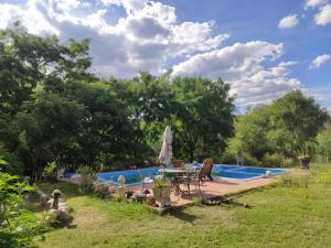 una piscina con tavolo e sedie in un cortile di Cabañas Yacoana a Valle Hermoso