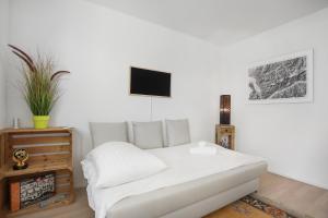 ein Wohnzimmer mit einem weißen Sofa und einem Fernseher in der Unterkunft Saillon, maison 5 pers - Terrasse - Parking privé in Saillon