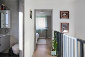 einen Flur mit einem Bad mit WC und einem Bett in der Unterkunft Saillon, maison 5 pers - Terrasse - Parking privé in Saillon + 39 Fotos