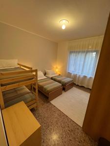 ein kleines Zimmer mit zwei Betten und einem Fenster in der Unterkunft La Grande Casa di Malpensa - casa vacanze in Gallarate