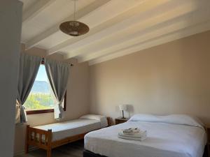 een slaapkamer met twee bedden en een raam bij Patagonia Suites in El Calafate