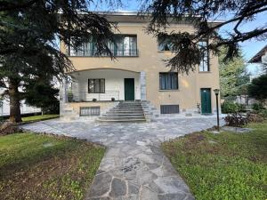 ein Haus mit einem steinernen Gehweg davor in der Unterkunft La Grande Casa di Malpensa - casa vacanze in Gallarate