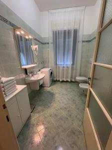 ein Badezimmer mit Waschbecken, Toilette und Spiegel in der Unterkunft La Grande Casa di Malpensa - casa vacanze in Gallarate + 58 Fotos