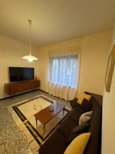 ein Wohnzimmer mit Sofa und Tisch in der Unterkunft La Grande Casa di Malpensa - casa vacanze in Gallarate