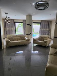 een woonkamer met 2 banken en 2 ramen bij Villa Amani in Somone