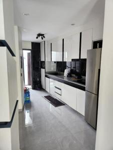 een keuken met witte kasten en roestvrijstalen apparaten bij Villa Amani in Somone