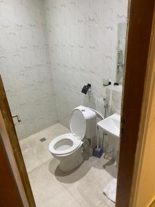 een badkamer met een wit toilet en een wastafel bij Appartement Case de Gaule in Brazzaville