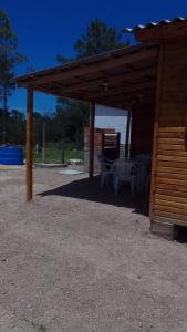 a wooden pavilion with a table and chairs under it at Cabaña Las Abuelas in Xuí