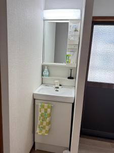 a small bathroom with a sink and a mirror at りんくう館笠松 関西空港 in Sano +30 photos