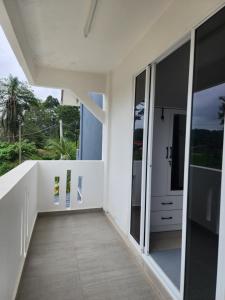 a hallway of a white house with glass doors at Warisan Iman Inn in Klang