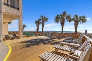 een terras met banken en palmbomen en de oceaan bij Sea Pointe 2BR Condo Oceanview, Views, Large Condo in Myrtle Beach