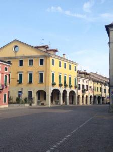 un grande edificio giallo sul lato di una strada di Macri a Montagnana