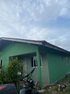 een kas met twee honden die ervoor staan bij Casa a 3km da PRAIA Central in Guaratuba