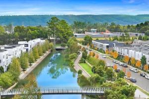 an aerial view of a city with a river at Cozy 4BR Family Haven Walk to Penrith CBD&Train in Penrith