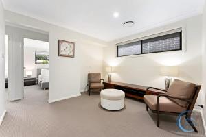 a hospital room with chairs and a bed and a window at Cozy 4BR Family Haven Walk to Penrith CBD&Train in Penrith +24 photos